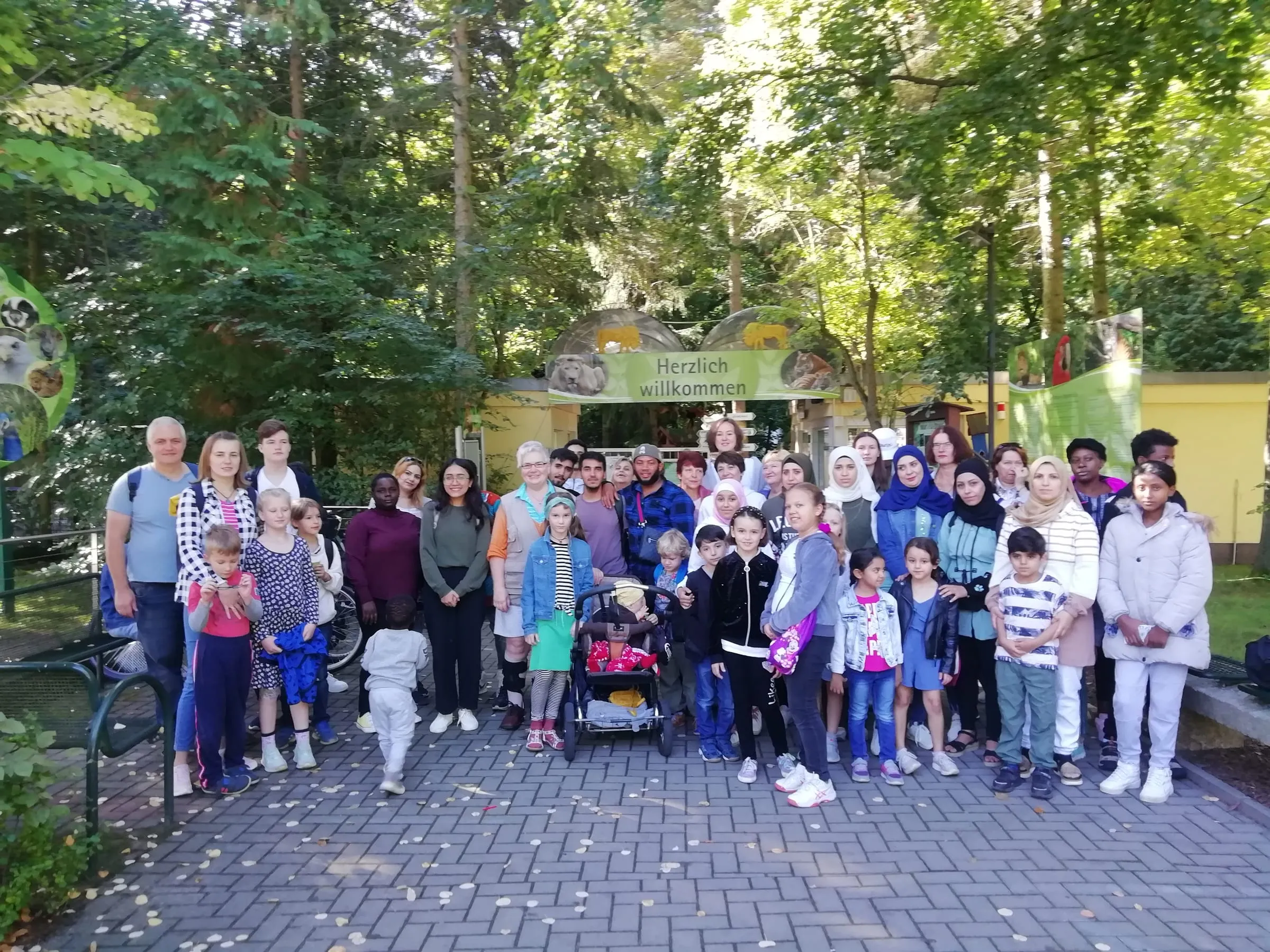 Deutschkurs-Teilnehmende & deren Kinder mit Deutschlehrerin Mirjam Silber vor dem Zooeingang